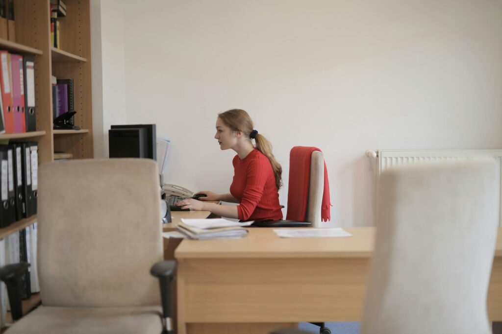 woman in red long sleeve shirt sitting on red chair